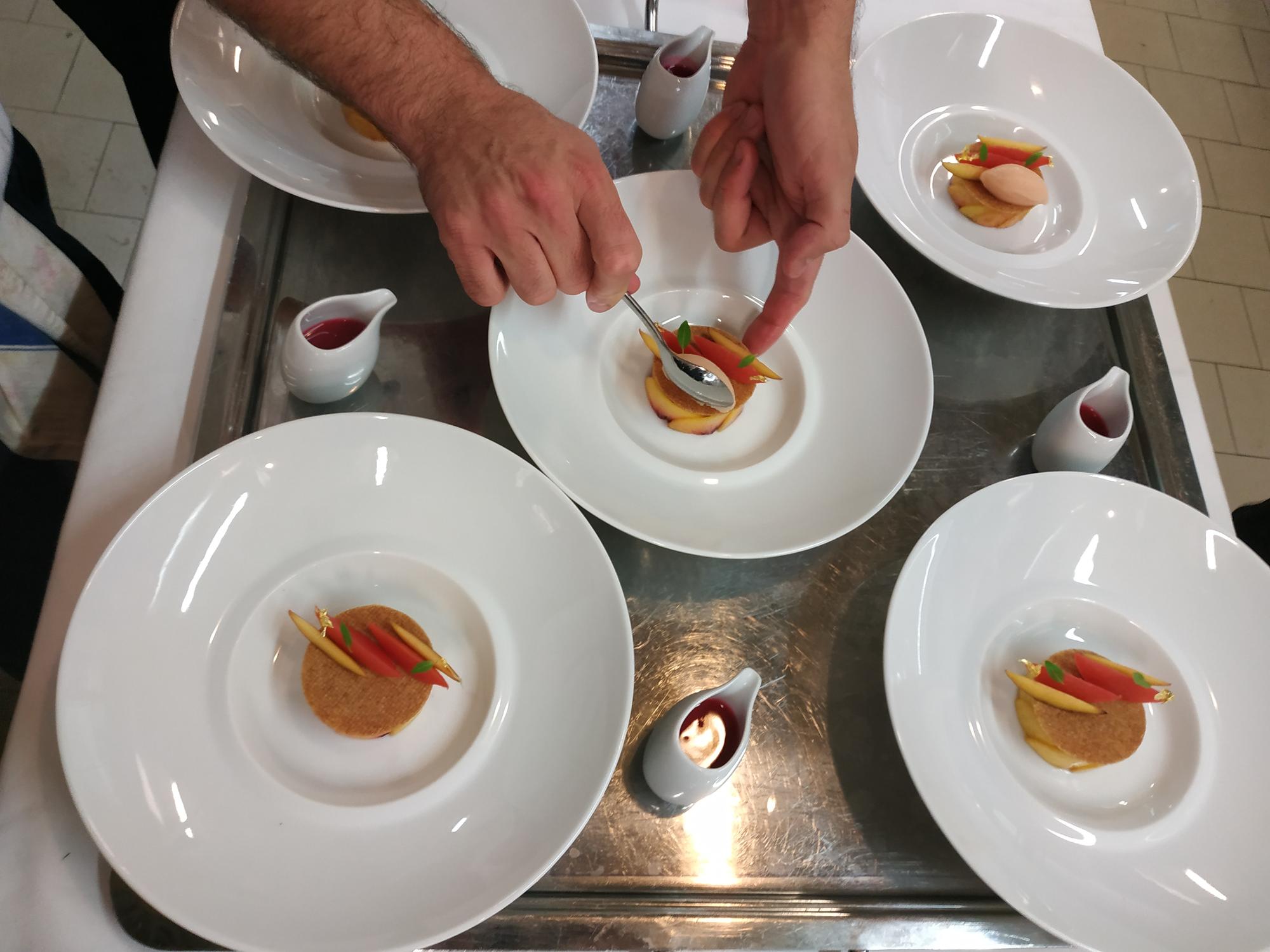 Chef in workshop arranging plates at a long table