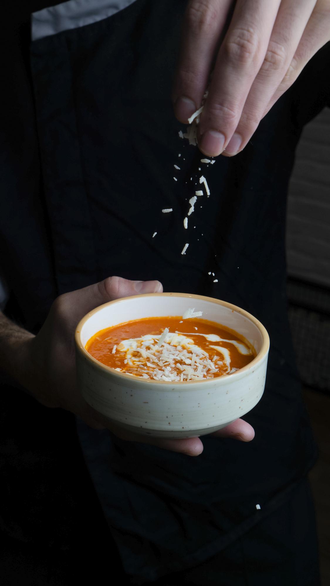 Chef hand finishing sauce on dish